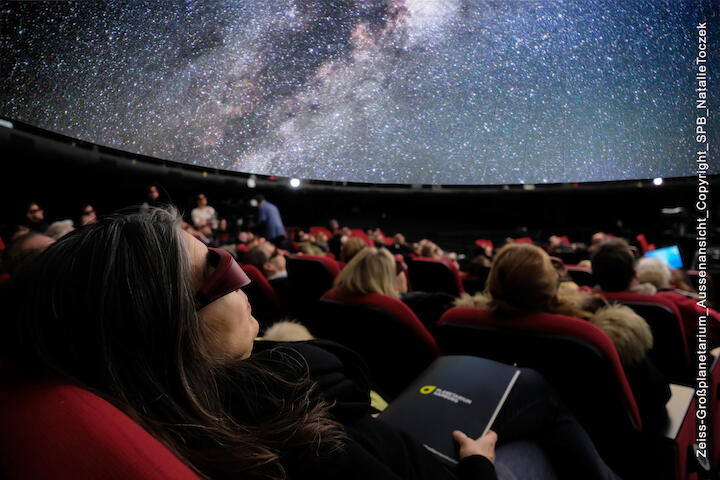 Menschen sitzen im Planetarium