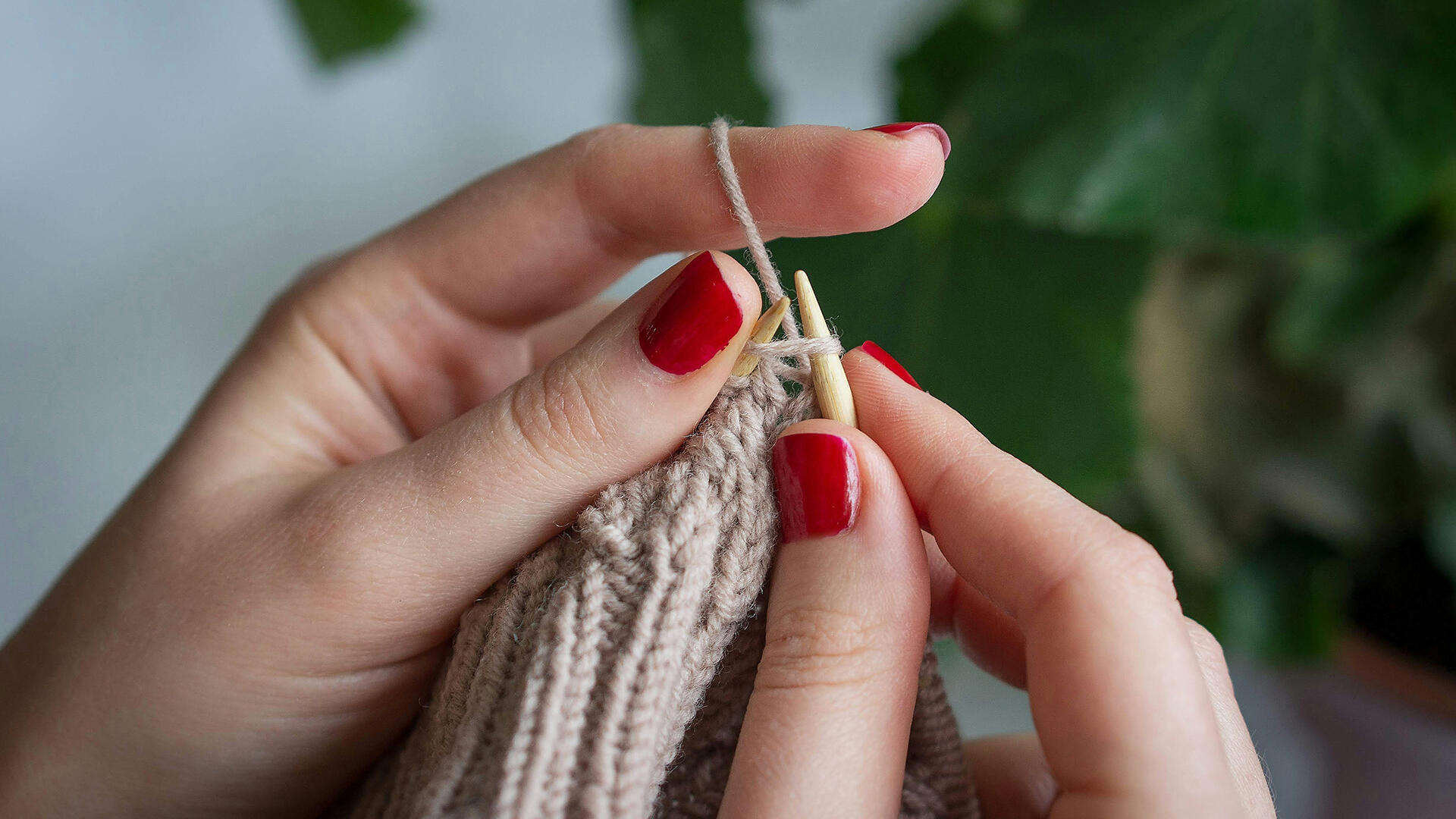 Frauenhände stricken etwas.