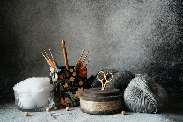 Stricknadeln, Garn, Stoff und Schere