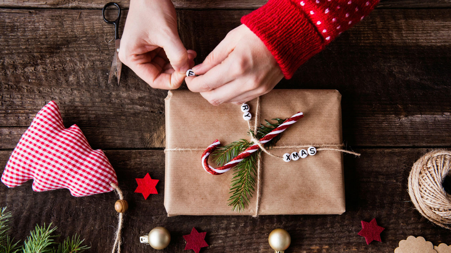 Ein Mensch packt ein Weihnachtsgeschenk ein