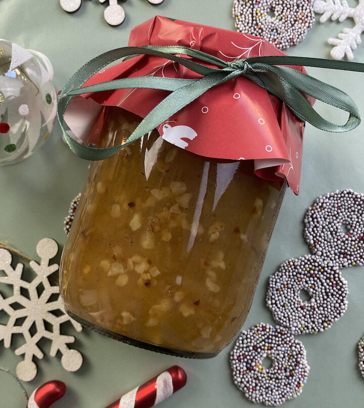 Bratapfelmarmelade hübsch verpackt auf einem weihnachtlich geschmückten Tisch