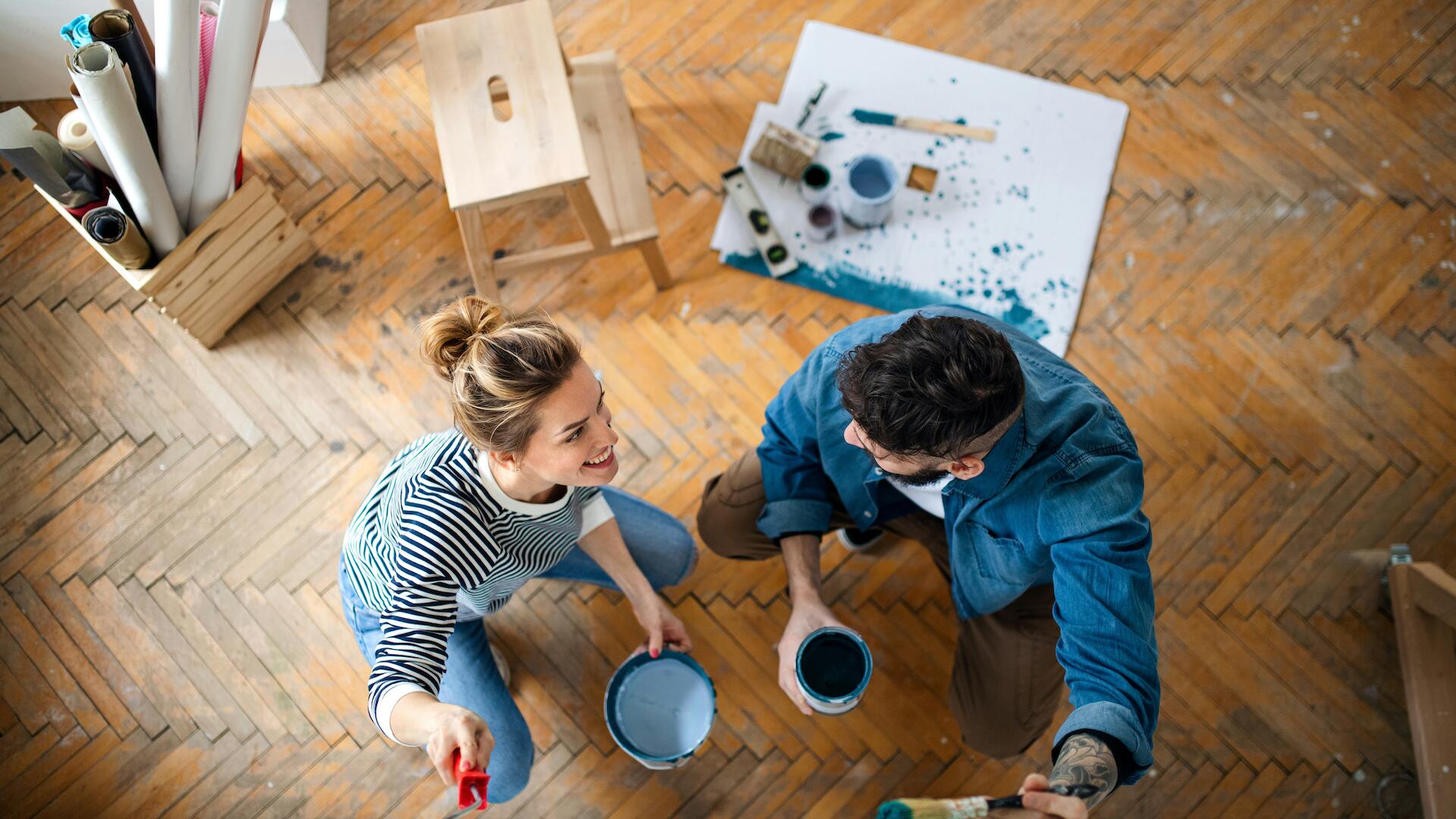 Eine Frau und ein Mann streichen eine Wand