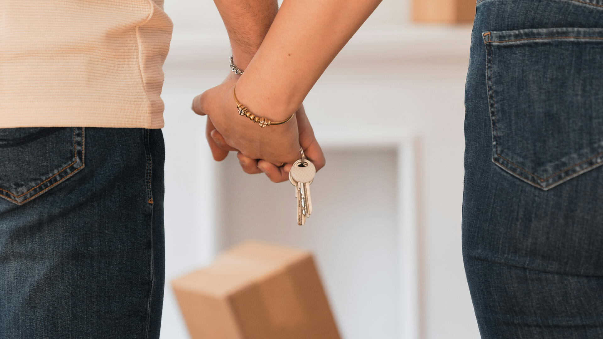 Zwei Hände verschränken die Finder ineinander und halten zusammen ein Schlüsselbund.