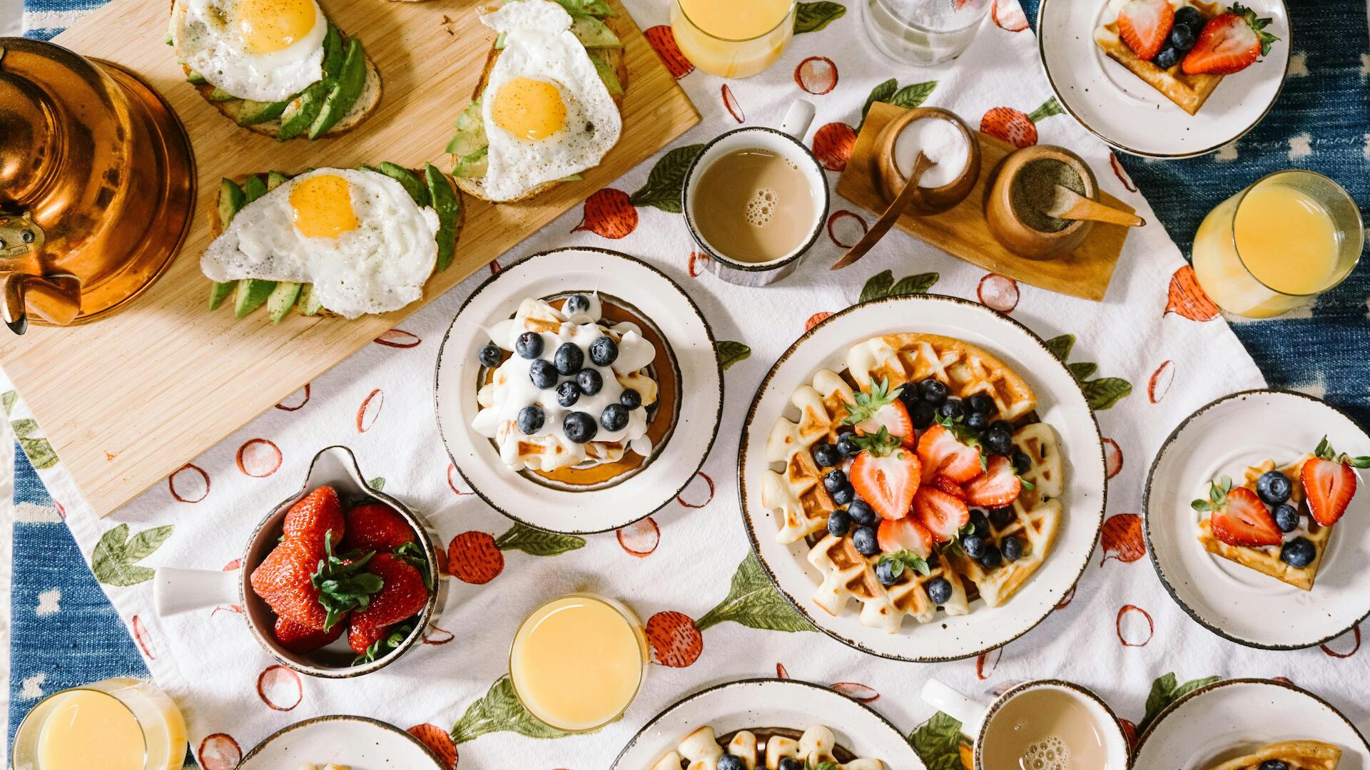 Ein Frühstücksbrunch mit Waffeln, Ei und Joghurt mit Früchten