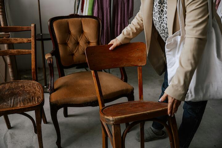 Eine Person nimmt einen Vintagestuhl im Laden in die Hand