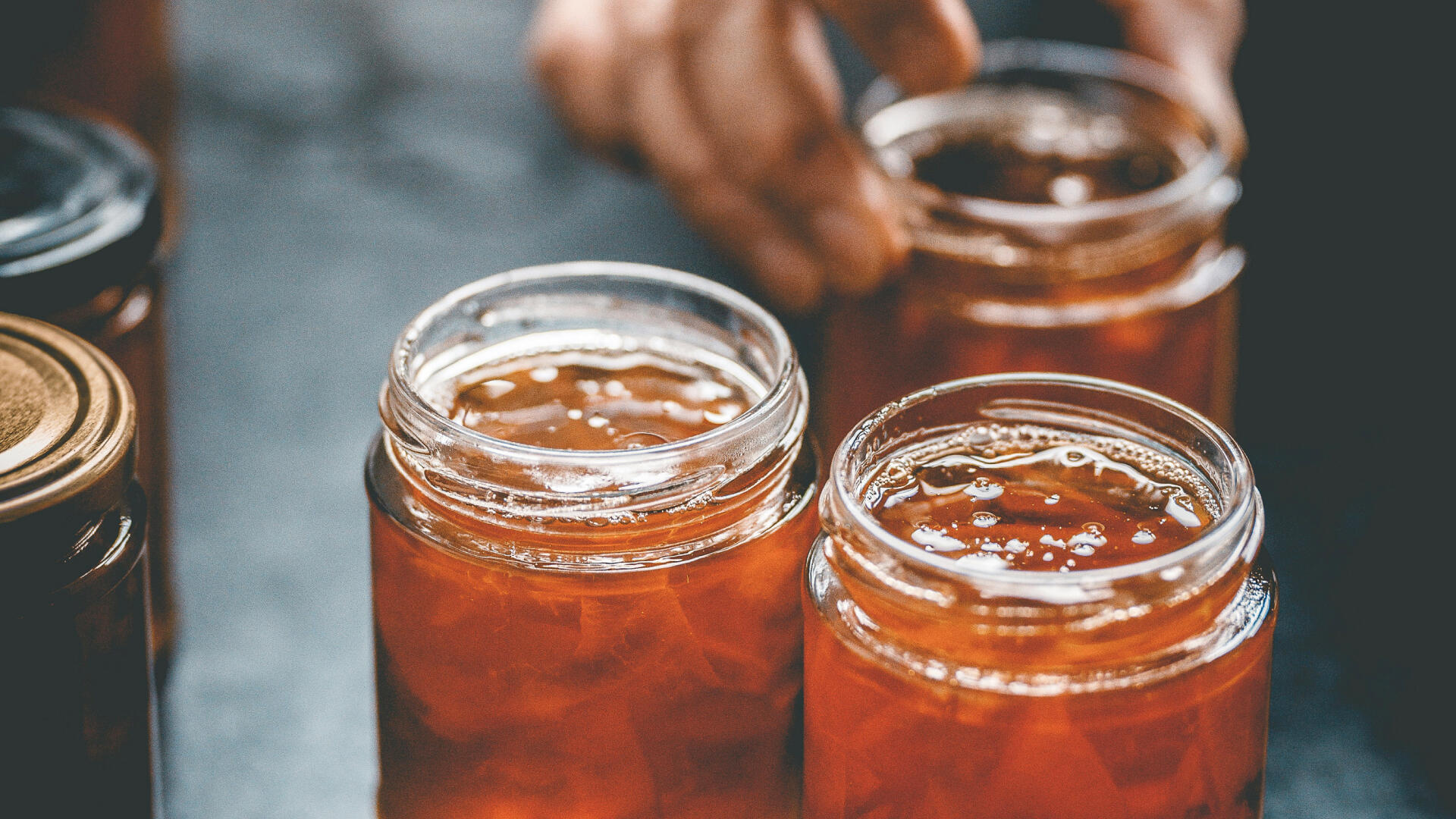 Offene Gläser mit selbstgemachtem Chutney oder Marmelade.