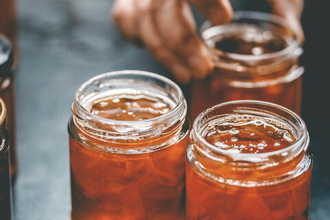 Offene Gläser mit selbstgemachtem Chutney oder Marmelade.