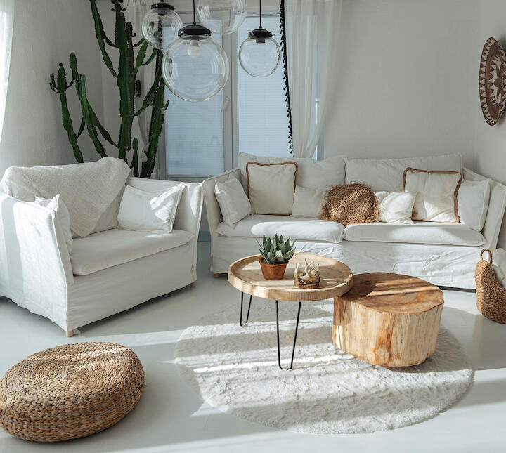 Gemütlicher Raum mit weißen Sofas und weißem, flauschigem Teppich unter dem Holzcouchtisch.