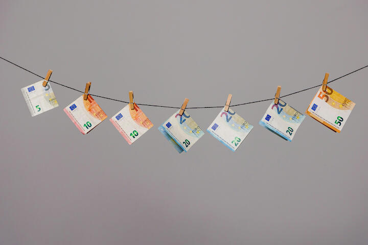 Verschiedene Euroscheine aufgehängt mit Wächeklammern an einer Wäscheleine.